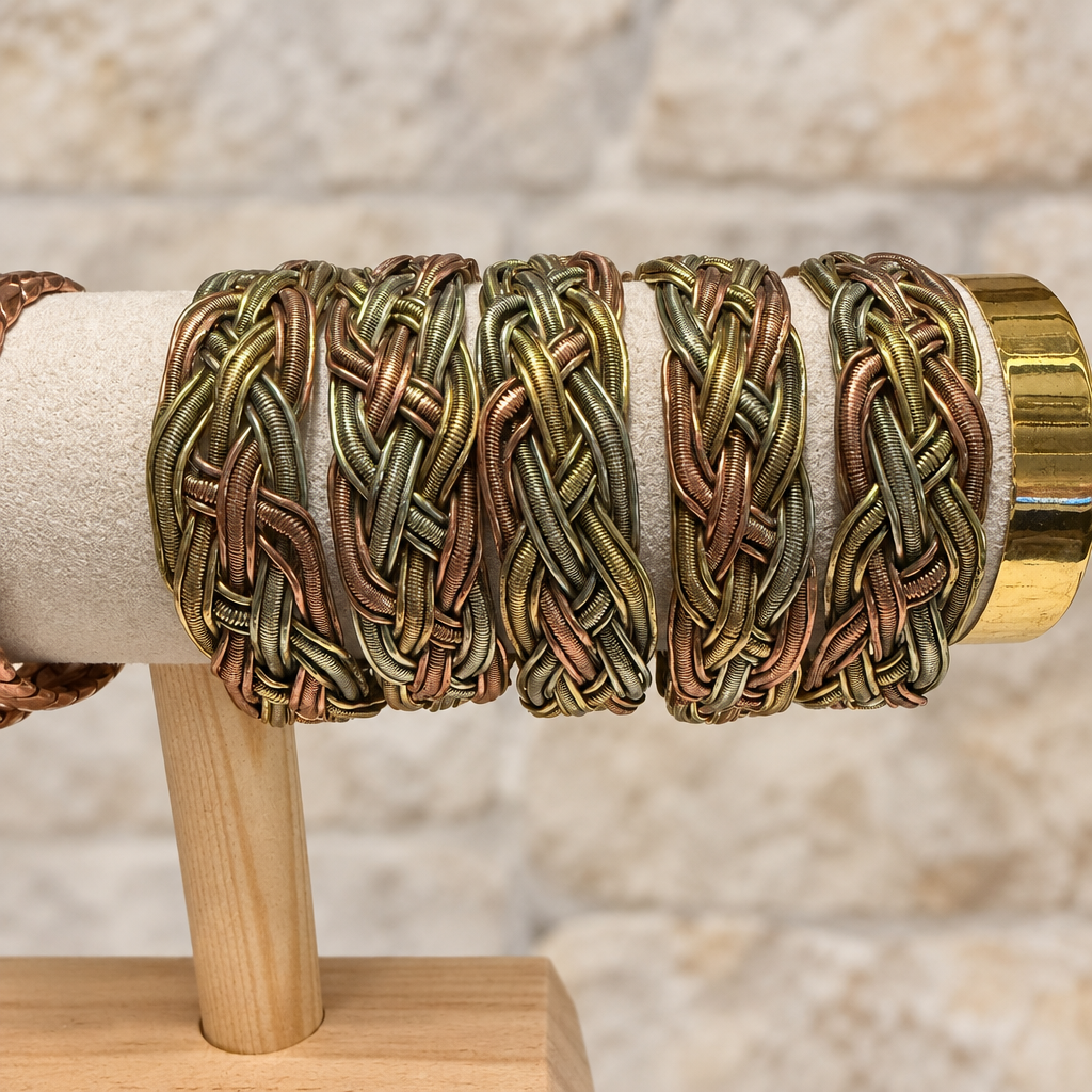 Bracciali intrecciati sull’espositore, sfondo pietra chiara