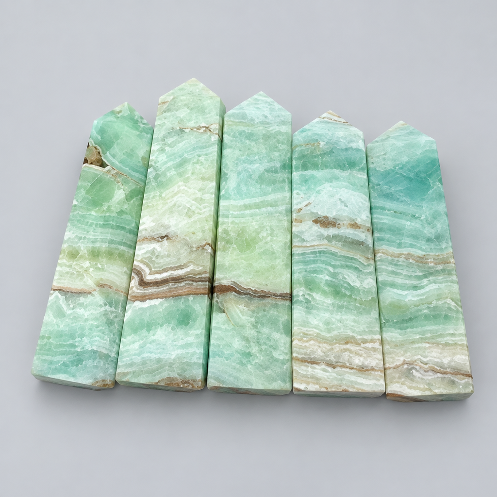 Obelischi in calcite caraibica su sfondo grigio chiaro