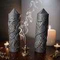 Torri di shungite con drago scolpito su legno scuro con incenso e candele
