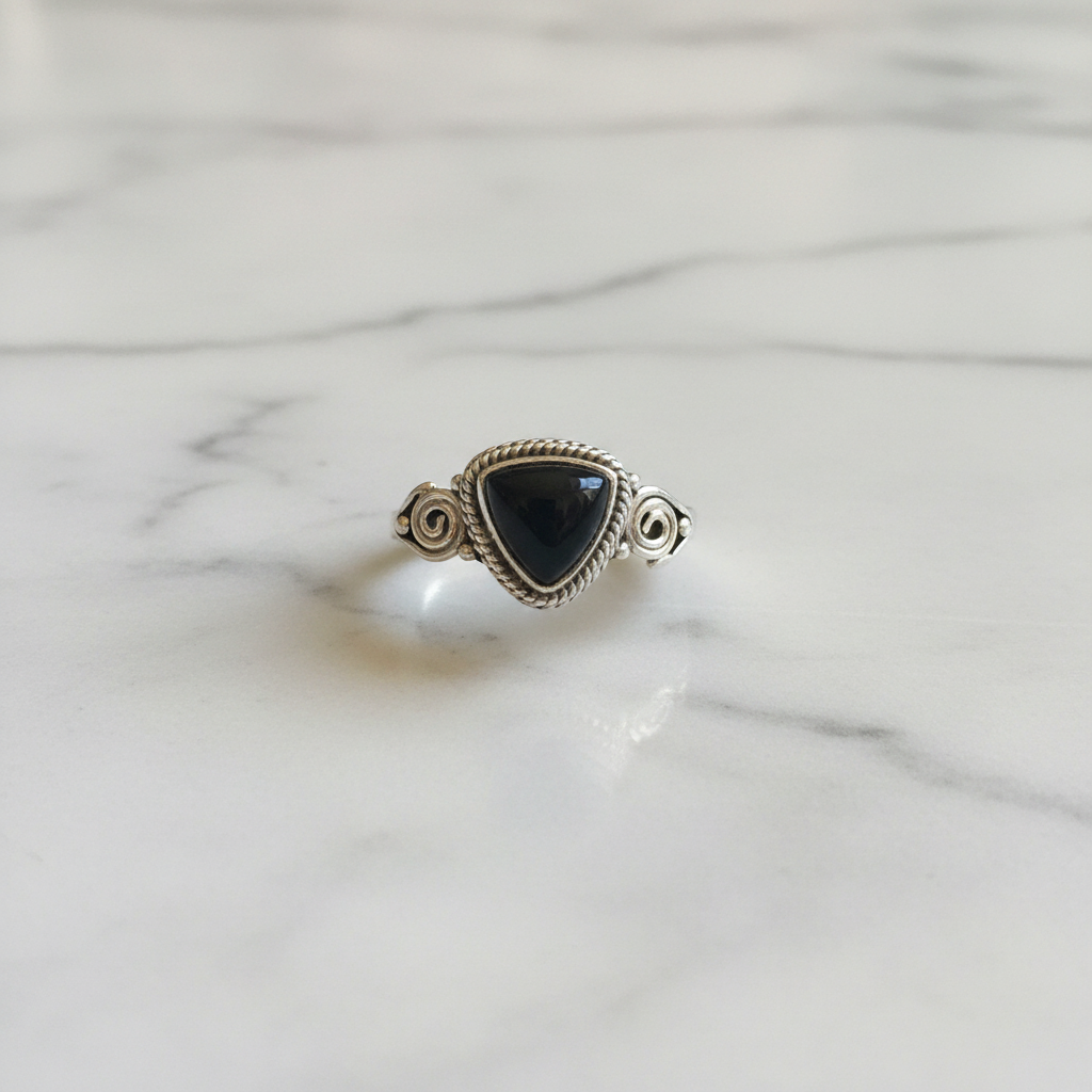 Anello ossidiana nera argento flatlay su marmo