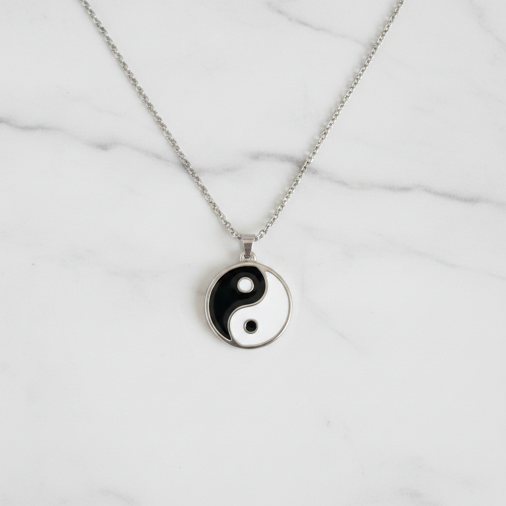 Collana Yin Yang smalto bianco nero flatlay su marmo