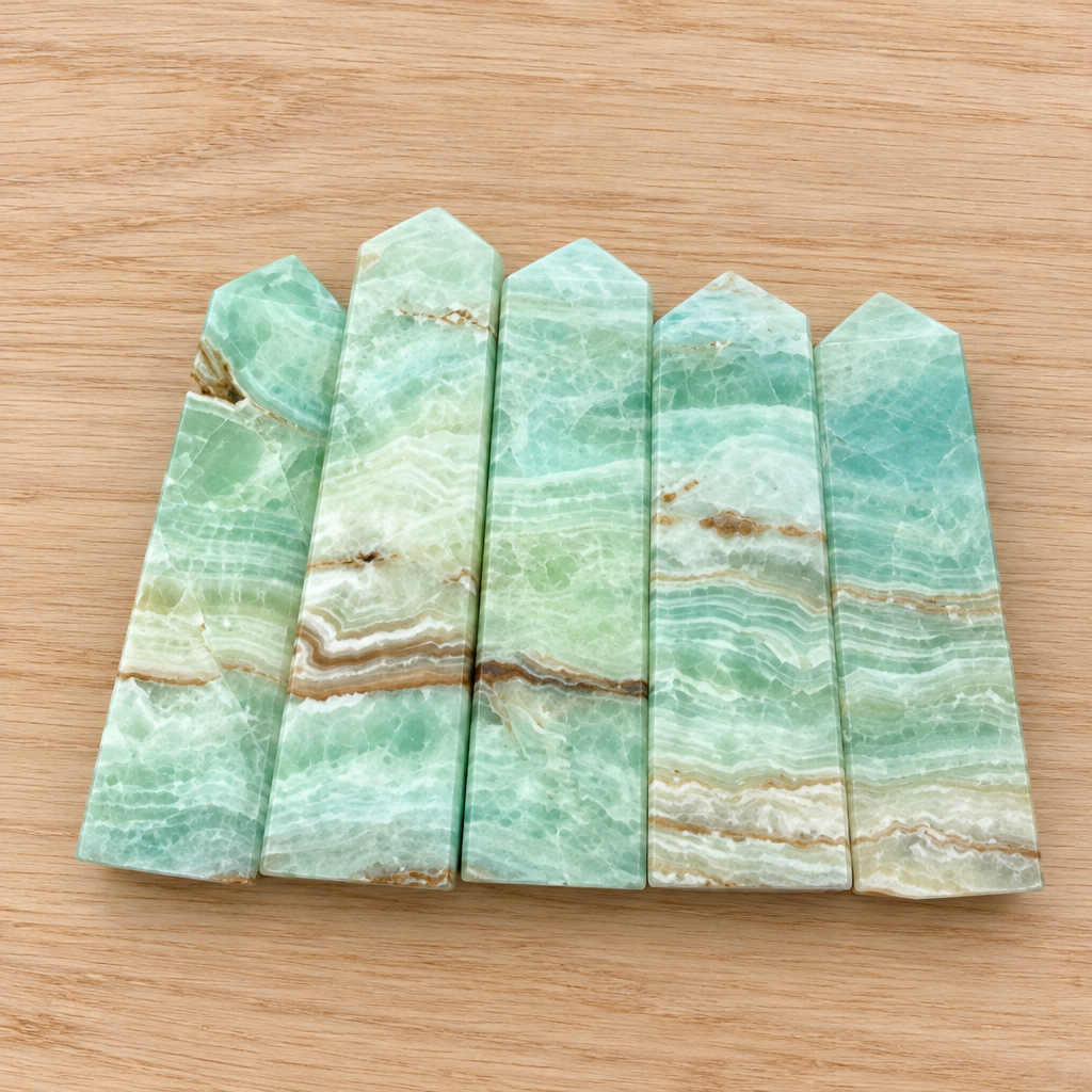 Obelischi in calcite caraibica su legno chiaro