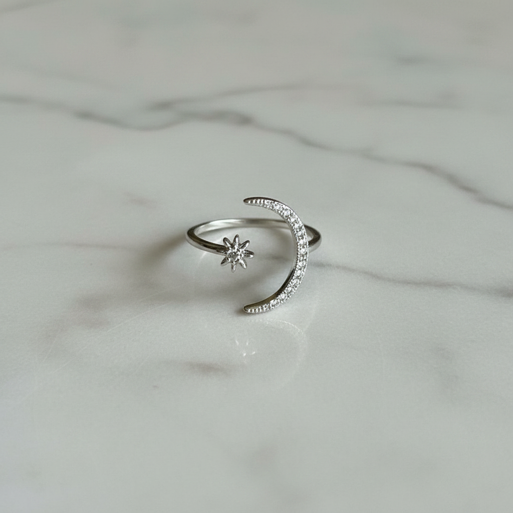 Anello regolabile color argento con sole e luna su marmo chiaro