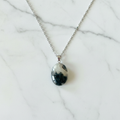 Collana agata muschiata flatlay su marmo