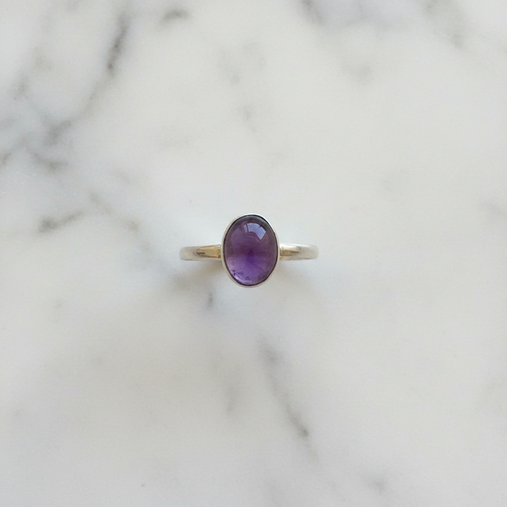 Anello ametista argento flatlay su marmo