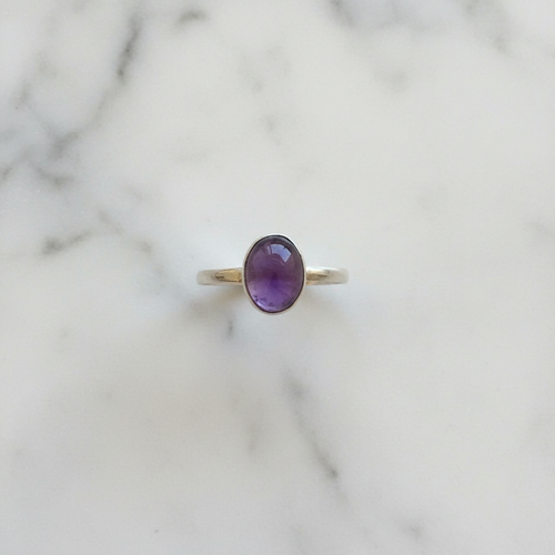 Anello ametista argento flatlay su marmo