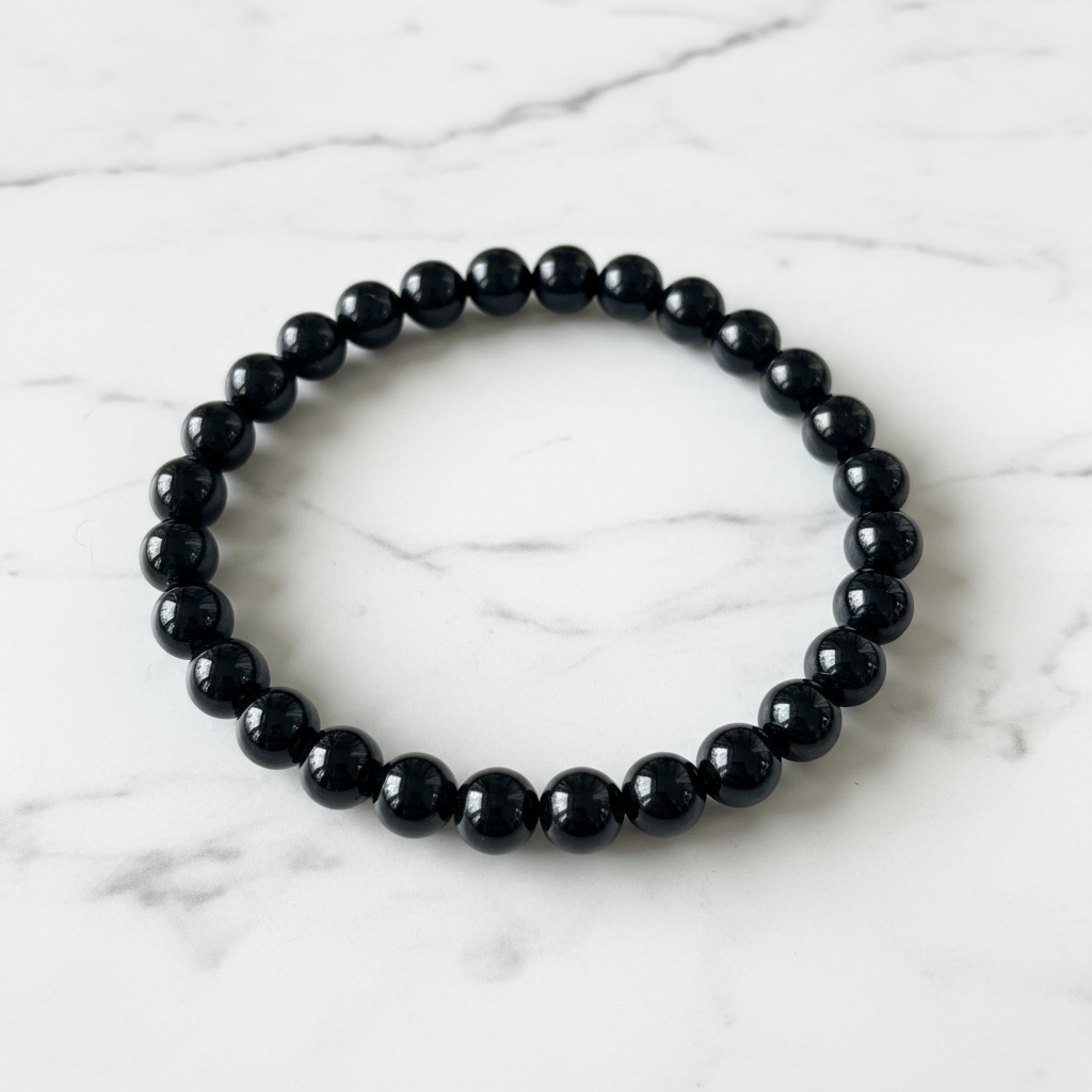 Bracciale ossidiana nera flatlay su marmo