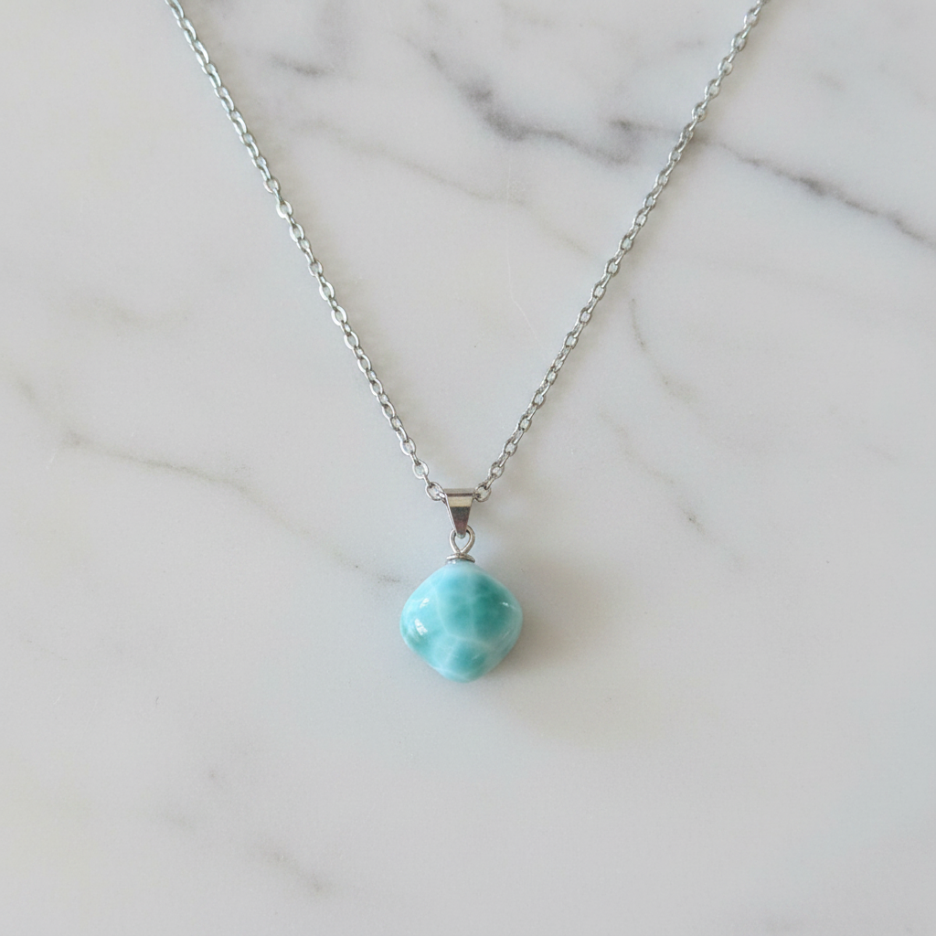 Collana larimar flatlay su marmo