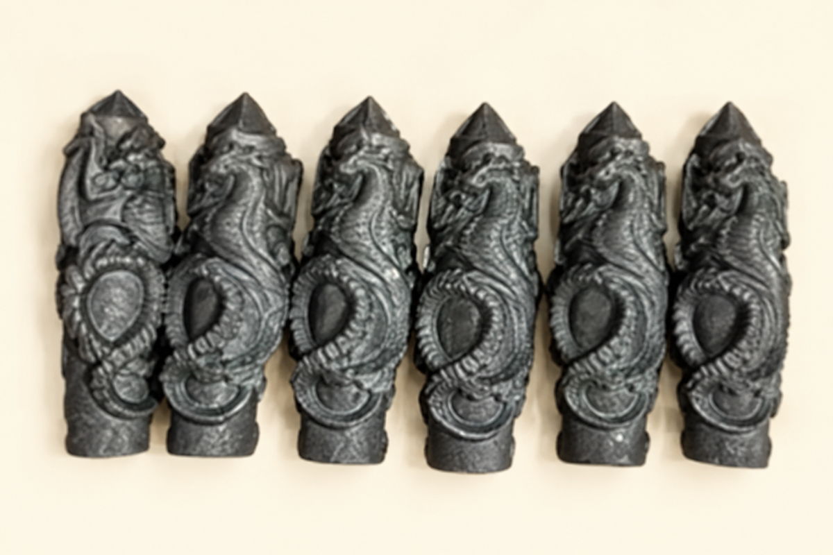 Obelischi di shungite con drago su sfondo avorio