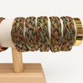Bracciali intrecciati sull’espositore originale, sfondo bianco