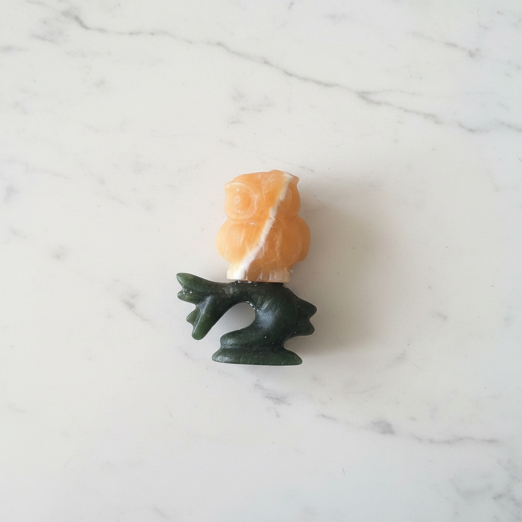 Gufo calcite gialla su ramo giada verde - flatlay su marmo