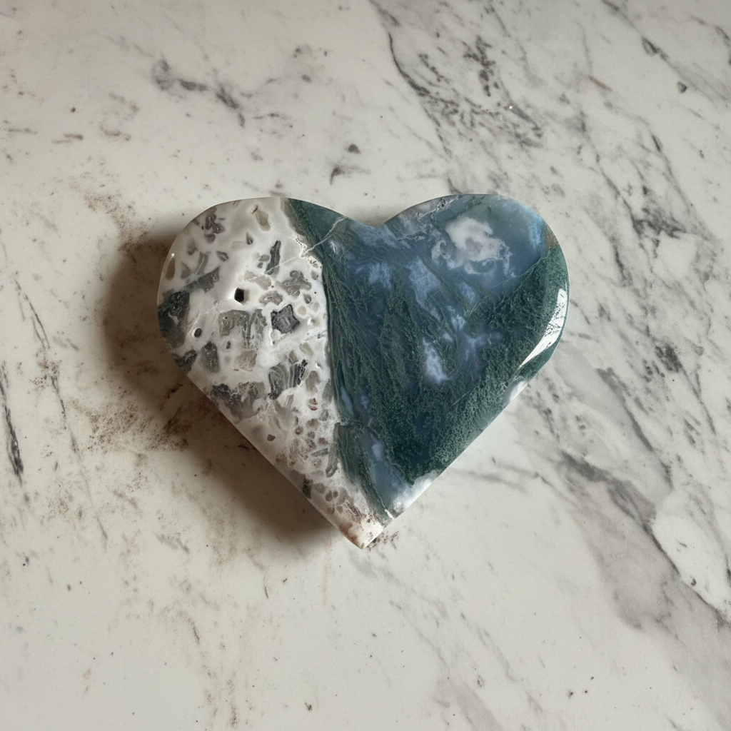 Cuore di agata muschiata lucidato su marmo chiaro