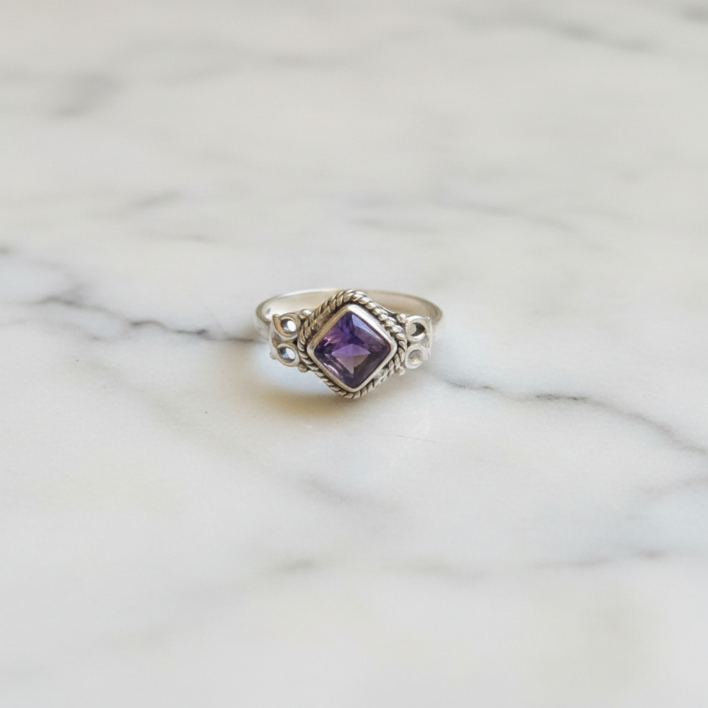 Anello ametista argento flatlay su marmo