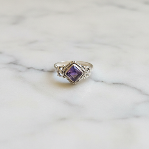 Anello ametista argento flatlay su marmo