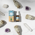 Olio salvia bianca Ullas - flatlay su marmo con salvia e cristalli