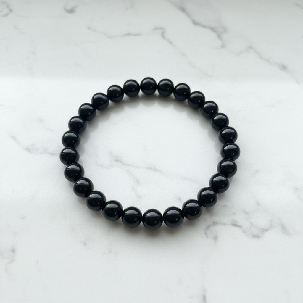 Bracciale onice nero 8mm flatlay su marmo