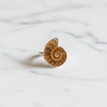 Anello ammonite su marmo bianco