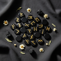 Rune in ossidiana con fiori bianchi, tormalina nera e salvia su lino scuro