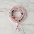 Japamala 7 chakra quarzo rosa flatlay su marmo