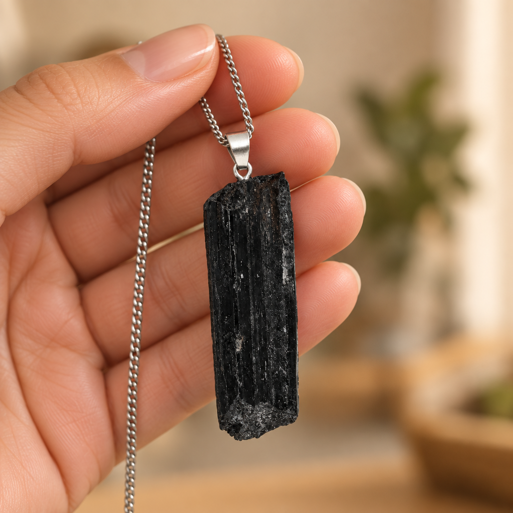 Pendente in tormalina nera con collana tenuto in mano
